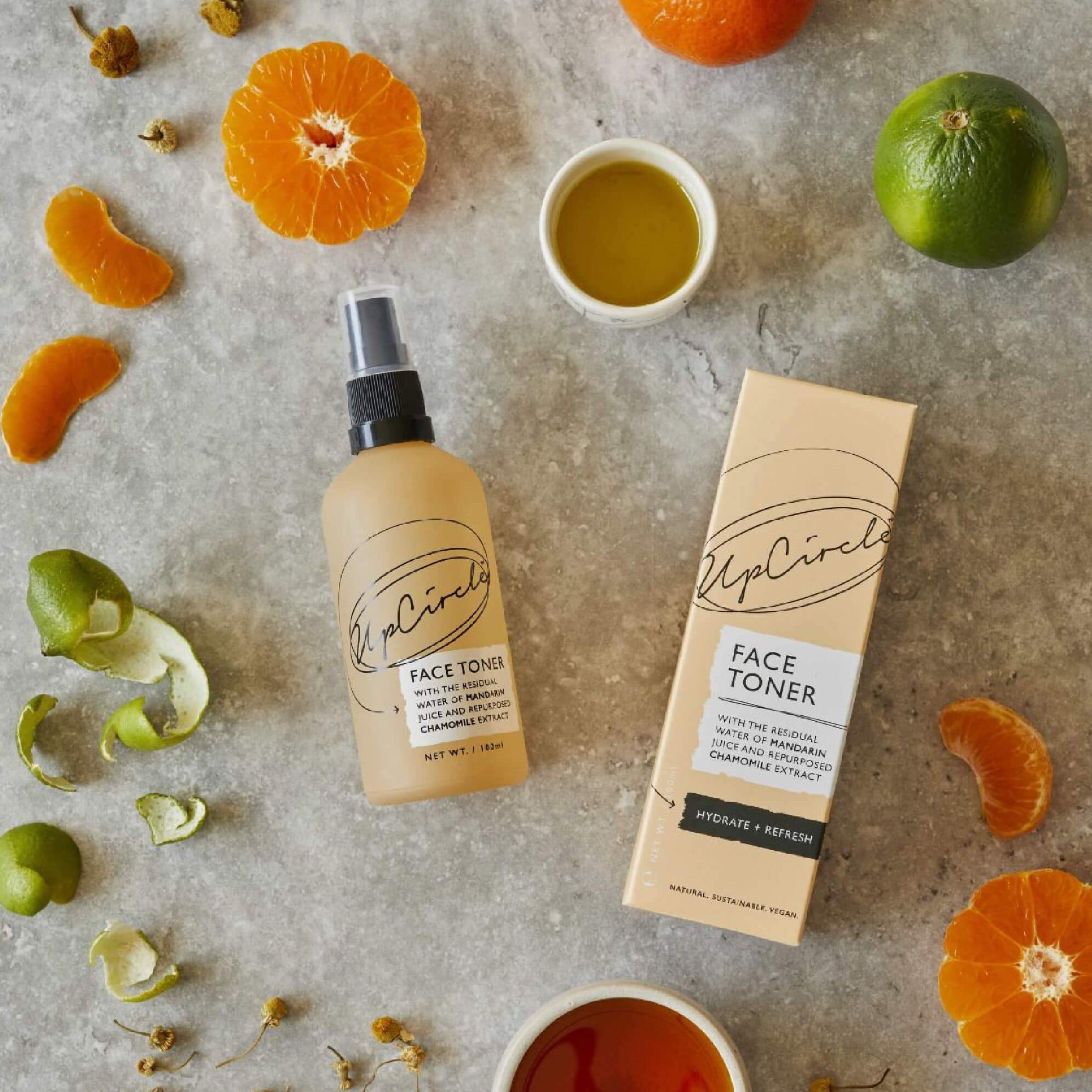 UpCircle face toner outside its package with orange and lime slices surrounding.