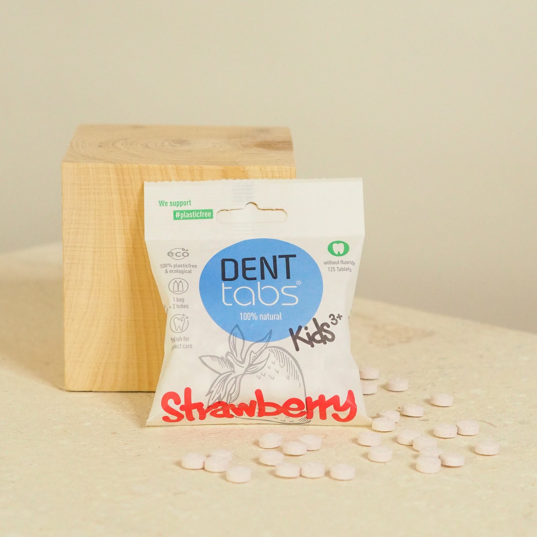 denttabs kids without fluoride next to block of wood