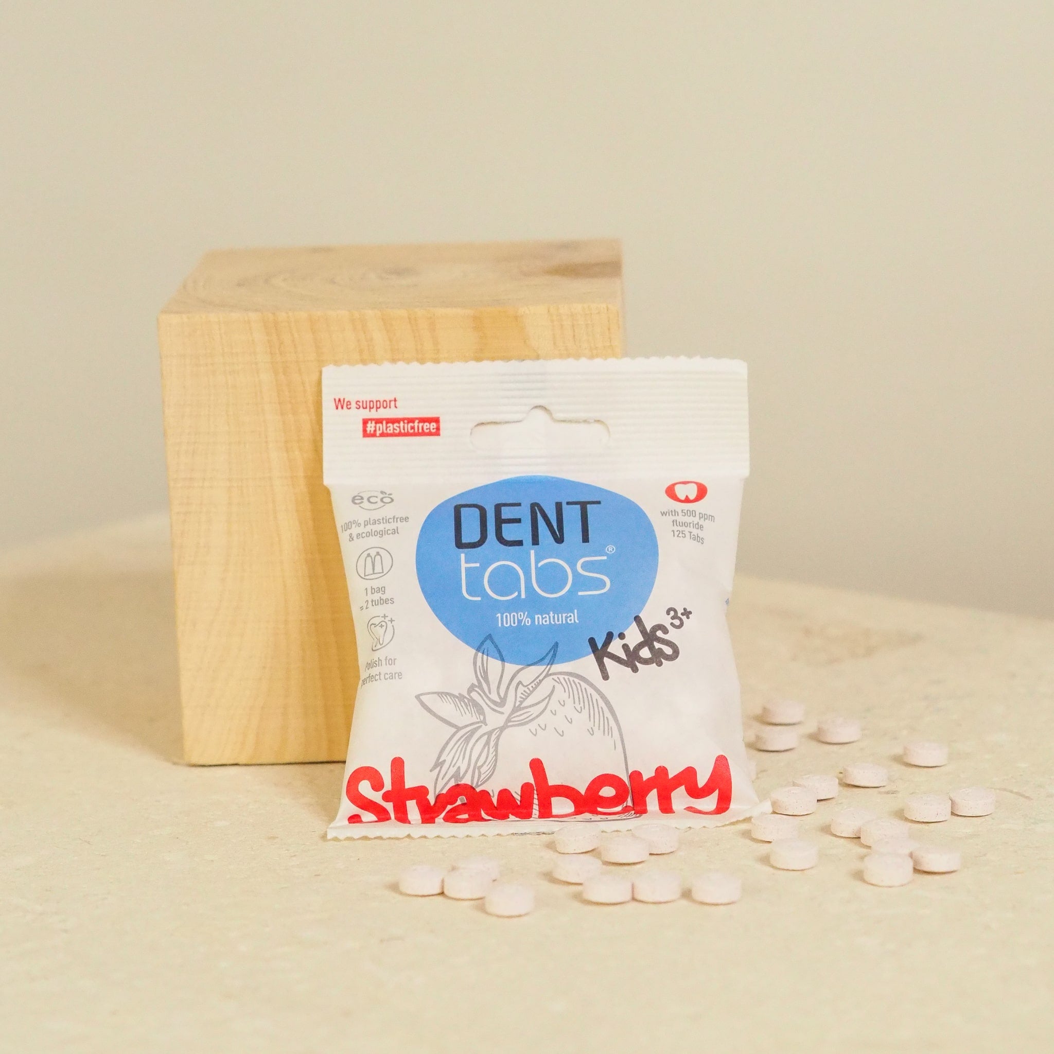 denttabs kids with fluoride next to block of wood